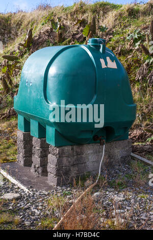 Plastic Domestic oil storage tank in a backyard, on breeze blocks. Stock Photo