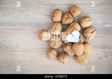 Heart shaped nutcracker on walnuts. Healthy eating concept. Walnuts are good for your heart. Stock Photo