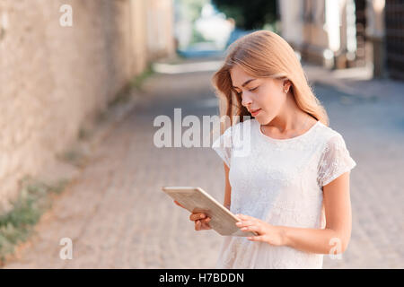 Young pretty woman using tablet computer outside a building Stock Photo