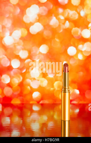 Red lipstick on red blurred background with reflection. Copy space included Stock Photo