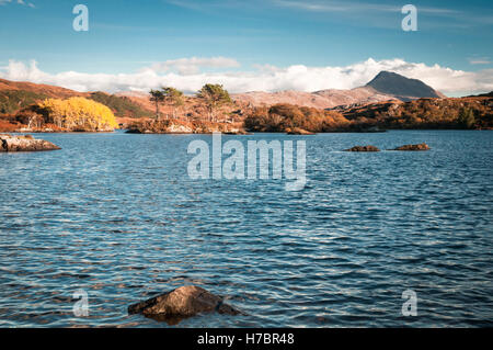 A landscape view of a distant Canisp across Loch Druim Suardalain, Assynt, Scotland. Stock Photo