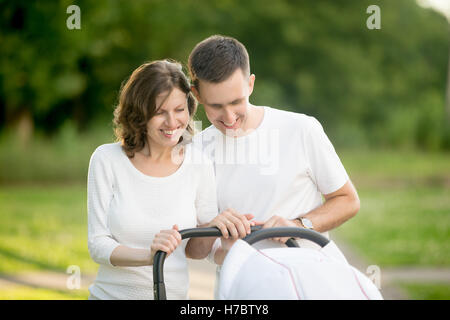 Happy parents walking with baby in park Stock Photo