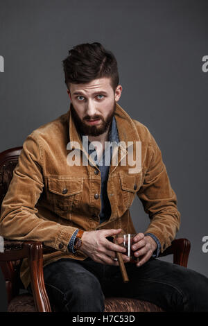 Portrait of serious bearded man with cigar and whisky Stock Photo