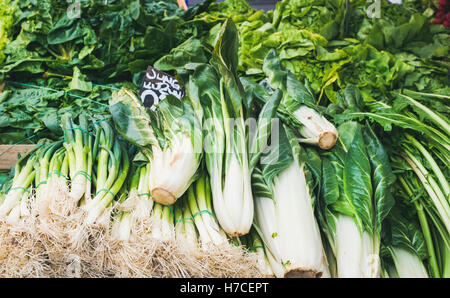 Various fresh green vegetables and herbs on market stall with price label in German at food market in Vienna Stock Photo