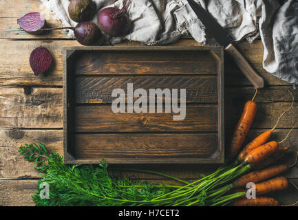 Healthy food cooking background. Vegetable ingredients. Fresh garden carrots and beetroots on rustic wooden background with wood Stock Photo