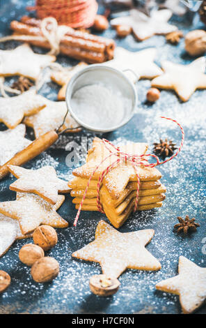 Homemade gingerbread star shaped cookies with cinnamon, anise and nuts on dark blue painted plywood background, selective focus, Stock Photo