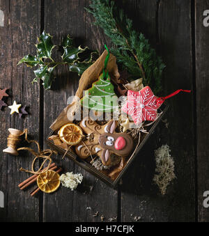 Christmas Handmade patterned gingerbreads as Christmas tree, reindeer Rudolph and snowflake shapes in wooden box over old wooden Stock Photo