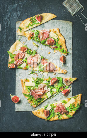 Fig, prosciutto, arugula and sage flatbread pizza on dark background Stock Photo