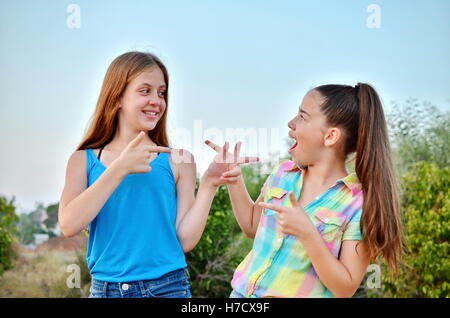 Best Friends Forever - two 12 year old teenage girls looking at each other with a surprised emotion Stock Photo