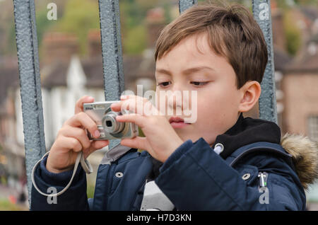 A young boy taking a photograph on the iron bridge at Ironbridge in Shropshire, UK. Stock Photo