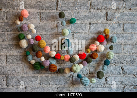 Colorful yarn balls decorate the brick wall in a texture store in small town Twisp, Washington, USA. Stock Photo