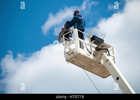 A television cameraman shoots a sporting event from an elevated camera platform Stock Photo