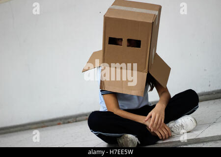 Photograph of a teen with a carton head mask Stock Photo