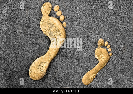 Golden right feet prints in a rocky surface Stock Photo