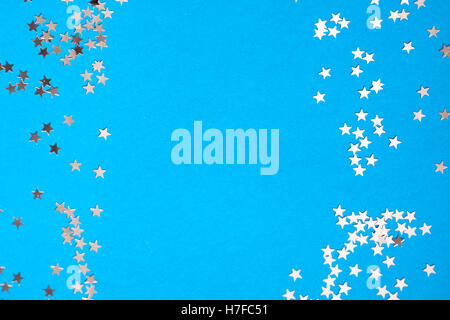 Frame of scatters little silver stars on blue background. Stock Photo