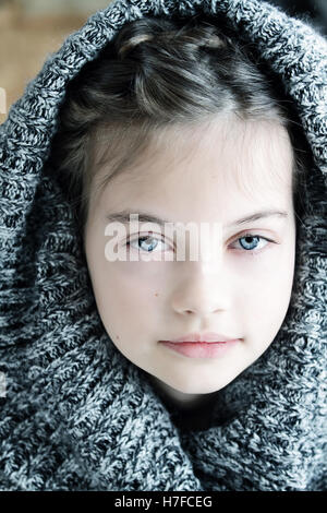 Studio shot of a beautiful young girl in a hooded sweater with shallow depth of field. Stock Photo