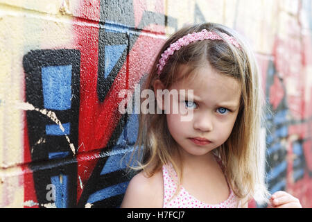 Worried little girl in an urban setting looking into the camera. Stock Photo