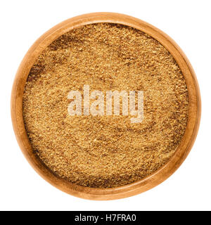 Dark coconut blossom sugar in a wooden bowl on white background. Raw brown unrefined sugar from the coconut palm. Stock Photo