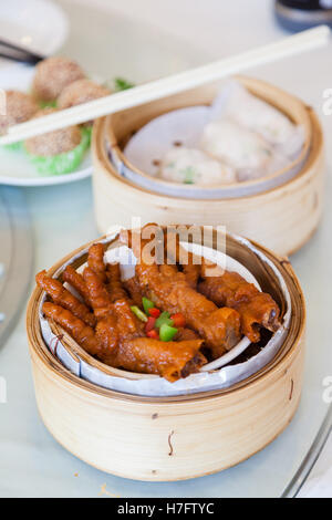 Braised chicken feet dim sum in bamboo steamer is a popular dish in Cantonese restaurants in Hong Kong. Stock Photo