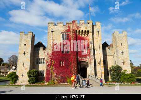 Hever Castle clad with red autumnal virginia creeper: Blue sky / sunny skies / sun & drawbridge / draw bridge over moat. Kent UK Stock Photo