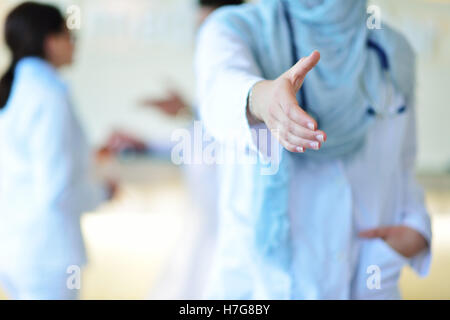 Young happy smiling female muslim doctor giving hand for handshaking Stock Photo