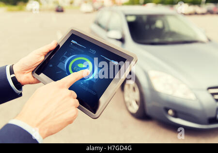 close up of male hands with tablet pc and car Stock Photo