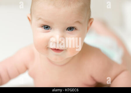 Portrait of an adorable smiling baby holds head up Stock Photo