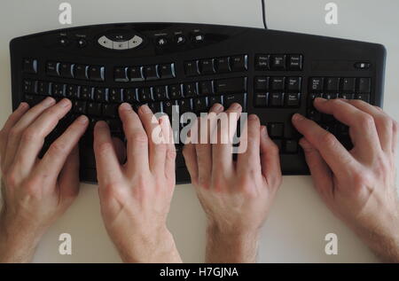 The activity 'Pair programming' in extreme programming and scrum illustrated by two pair of hands on the keyboard. Stock Photo