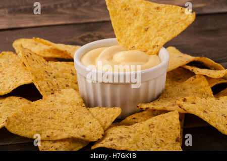 Nachos with cheese dip on an wooden table Stock Photo