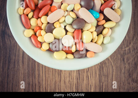 Vintage photo, Colorful medical pills, tablets, capsules or supplements for therapy on plate, concept of treatment Stock Photo