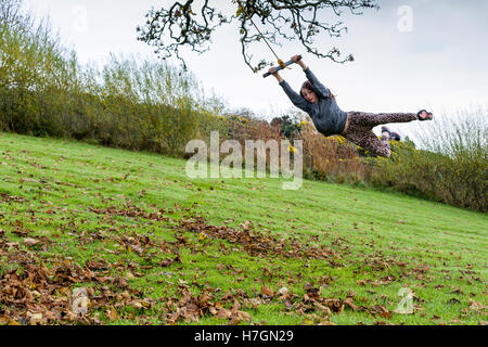 Teenage girl swinging on a rope swing outdoors  Model Release: Yes.  Property Release: Yes. Stock Photo