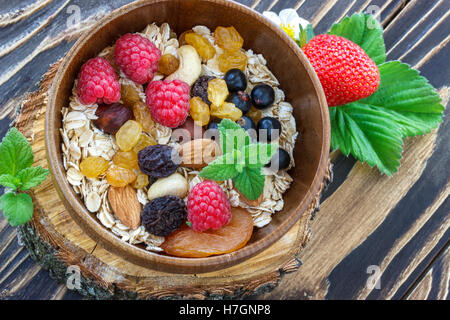 muesli and fresh berries, raisins and nutson a wooden table Stock Photo