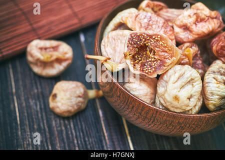 Dried figs in wooden bowl on table Stock Photo