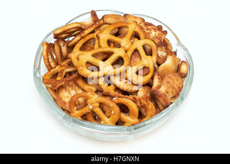 Mix of salty snacks (crackers and pretzels) in glass bowl isolated on white background Stock Photo