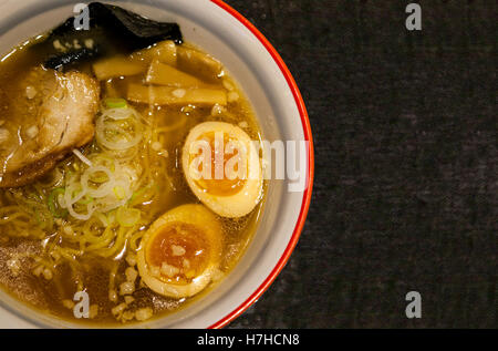 Japanese Shoyu soya sauce ramen adorned with marinated bamboo shoots (menma), green onions, nori (seaweed), boiled eggs. Stock Photo