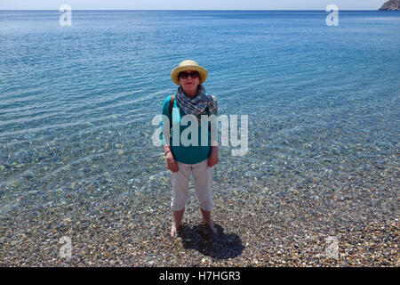 Smart mature woman paddling in the sea cooling off Stock Photo