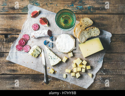 Glass of rose wine, cheese, cured sausage, fig, blueberry, bread Stock Photo