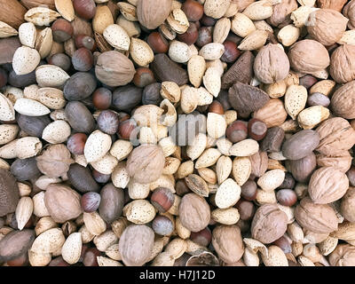 Several varieties of mixed nuts make a snack food background Stock Photo