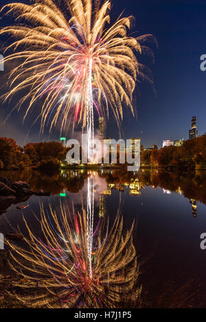 Central Park Fireworks celebrating the Marathon reflecting on the Lake. Midtown Manhattan, New York City Stock Photo