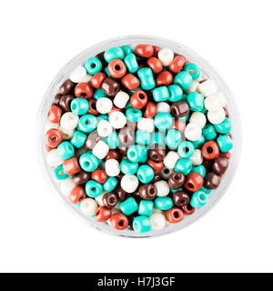 Small container of glass seed beads isolated on white background overhead view. Stock Photo
