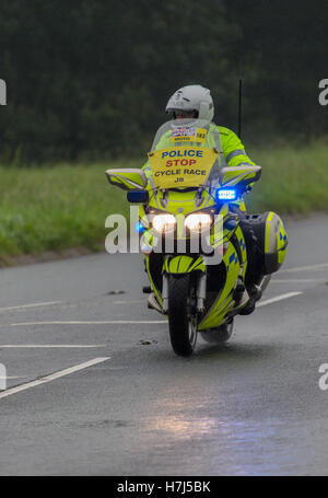 Motorcycle police officer clearing the way for the Tour of Britain Cycle Race entering Kendal in Cumbria Stock Photo