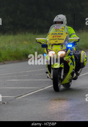 Motorcycle police officer clearing the way for the Tour of Britain Cycle Race entering Kendal in Cumbria Stock Photo