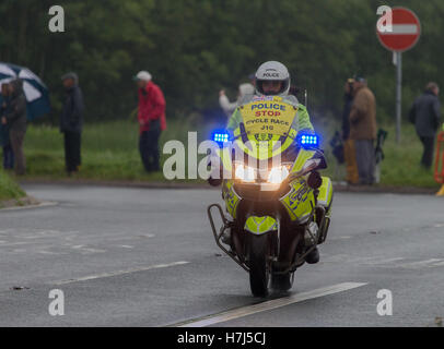 Motorcycle police officer clearing the way for the Tour of Britain Cycle Race entering Kendal in Cumbria Stock Photo