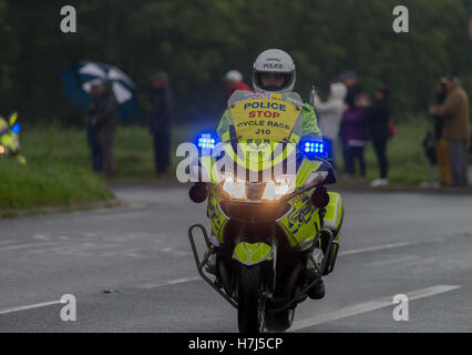 Motorcycle police officer clearing the way for the Tour of Britain Cycle Race entering Kendal in Cumbria Stock Photo