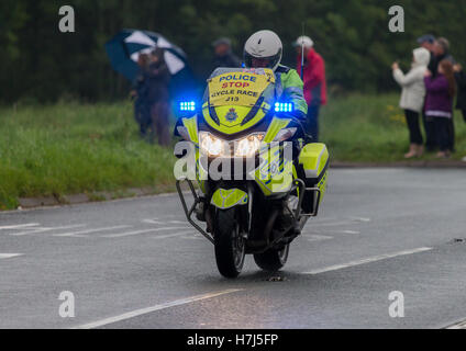 Motorcycle police officer clearing the way for the Tour of Britain Cycle Race entering Kendal in Cumbria Stock Photo