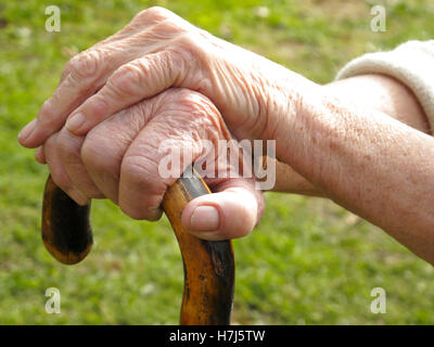 Hands of an old woman on a walking stick Stock Photo
