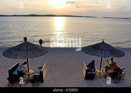 People enjoying the sunset in Fazana in front of Brioni islands Stock Photo