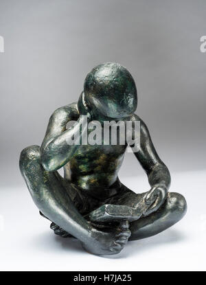 Young man reading, patinated plaster sculpture 1966 by French sculptor Jean Henninger Stock Photo