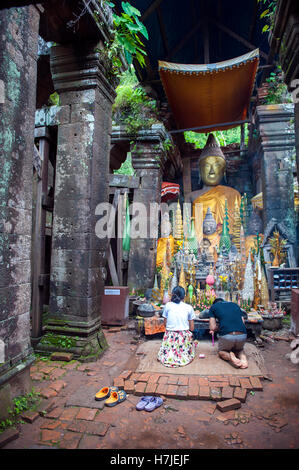 Buddhist devotees pray to Wat Phu, a ruined Khmer Hindu temple complex in Champasak in southern Laos. Stock Photo