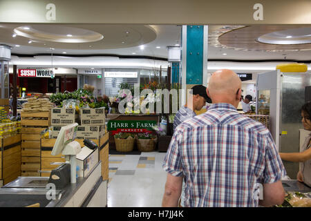 Men queue to pay for groceries at supermarket checkout, Harris Farm markets in Sydney,Australia Stock Photo